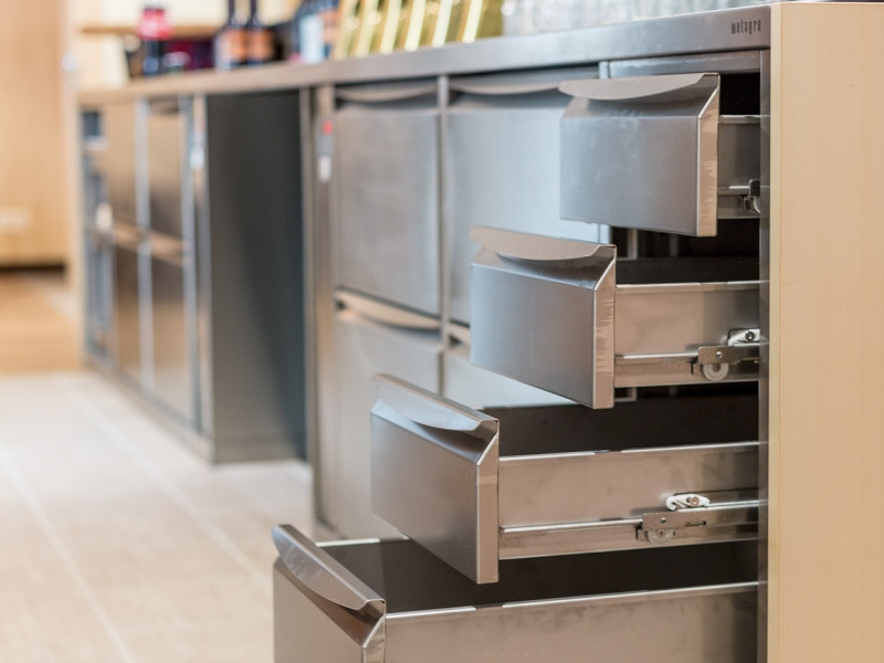 Schankverbau mit vier geöffneten Edelstahl-Laden im Vordergrund (im Hintergrund Getränkekühlung, Zapfsäulen, ...)