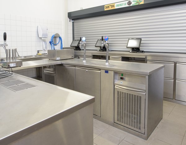 Schankverbau in Edelstahl mit Klappbord für individuelle Gestaltung der Arbeitsfläche und perforierter Flügeltür