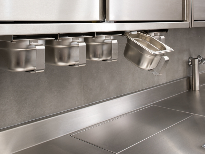 Detail-Aufnahme von GN-Gewürzschütten mit Griff (integriert in Wandhängeschrank)