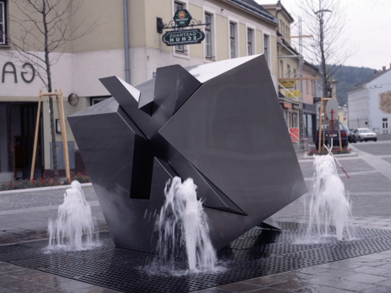 Edelstahl-Brunnen in Hainfeld: Dreidimensionales Andreaskreuz durchdringt Würfel (umgesetzt zwischen Professor Gottfried Höllwarth und Metagro)